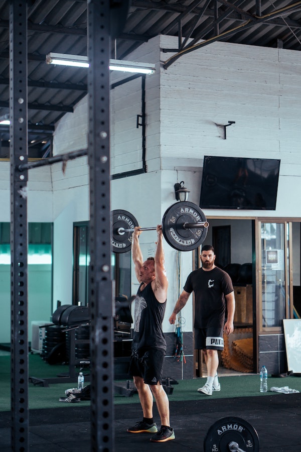 man doing overhead military press in gym