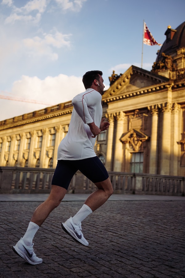 Man running past a large building in city