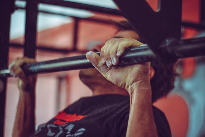 Man doing pull ups at the gym with pull up bar