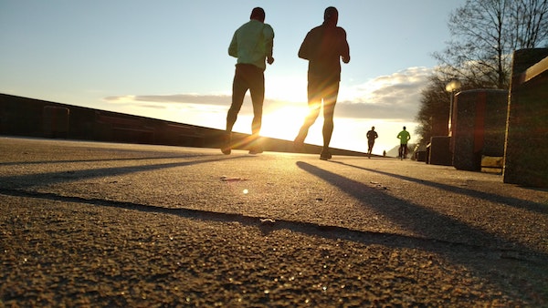 Two friends running on a path