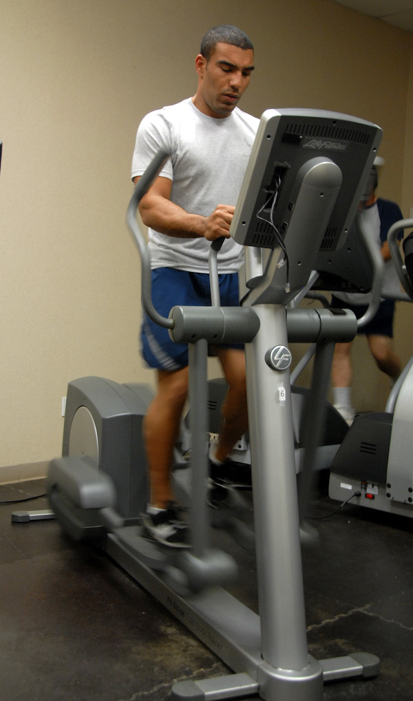 Man on an elliptical machine inside the gym