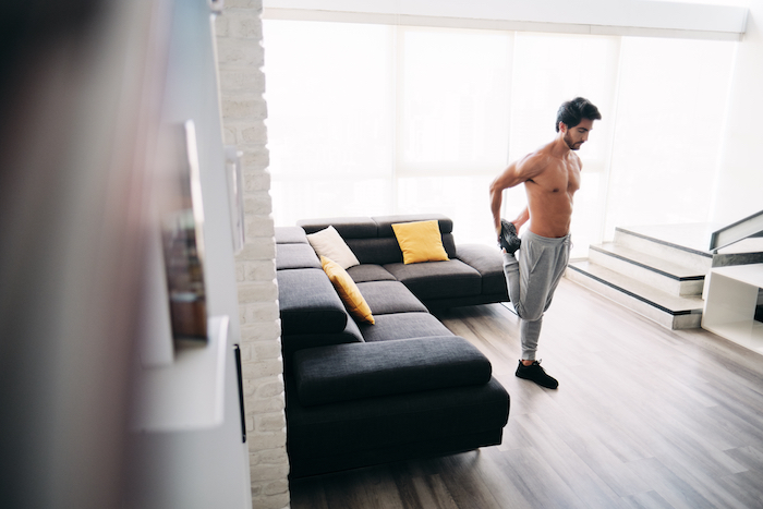 Man stretching and exercising in living room