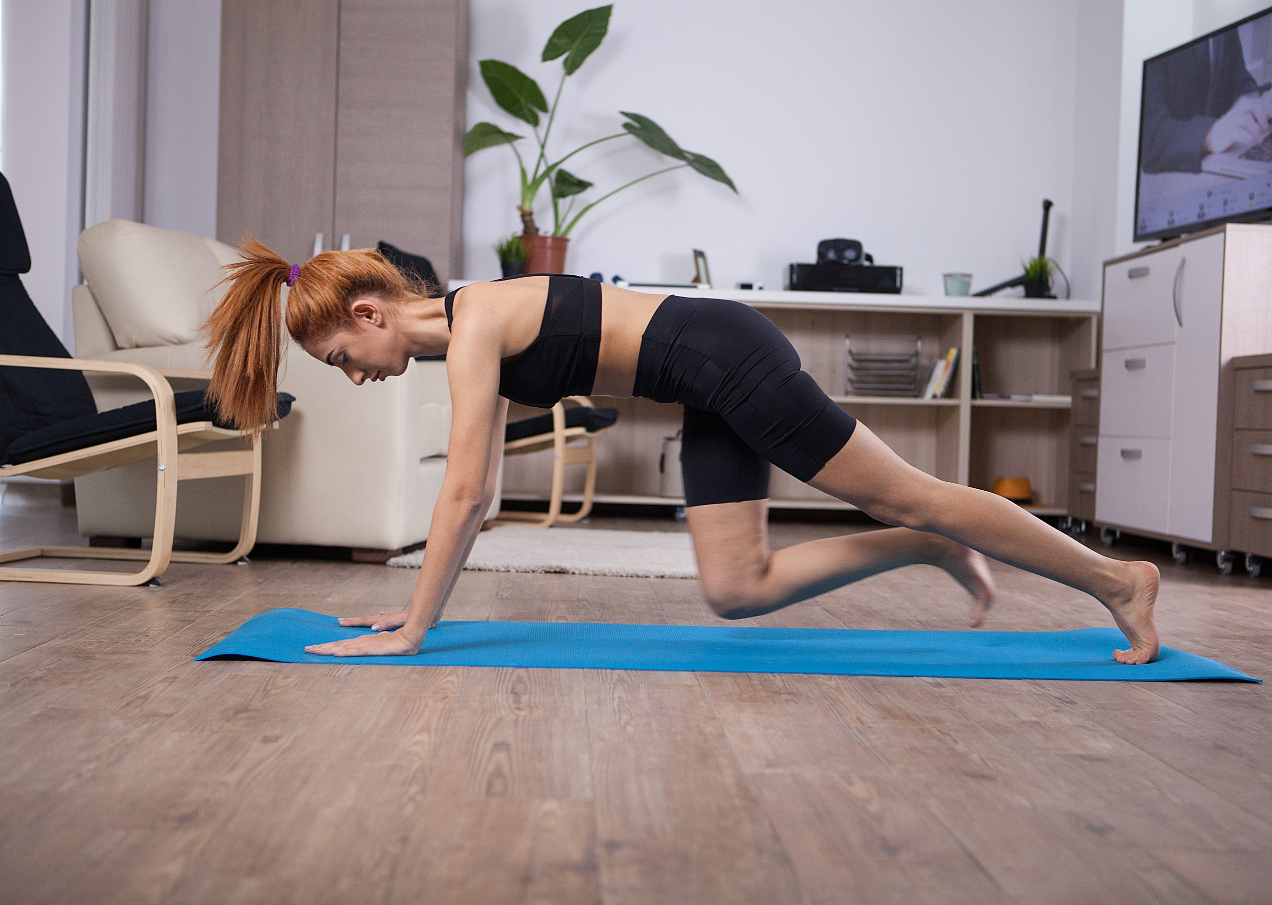 Woman working out on yoga mat at home