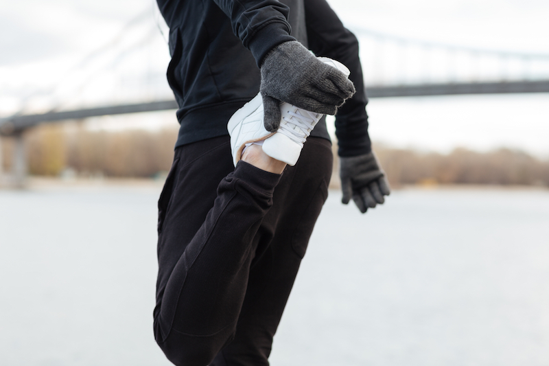 Person stretching before outdoor run in the cold