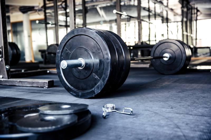 Barbell and bumper plates on gym floor