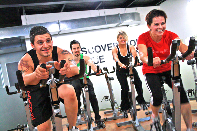 Happy people sweating in spin cycling class